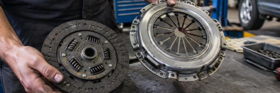 Mecánico sosteniendo un disco de clutch de auto